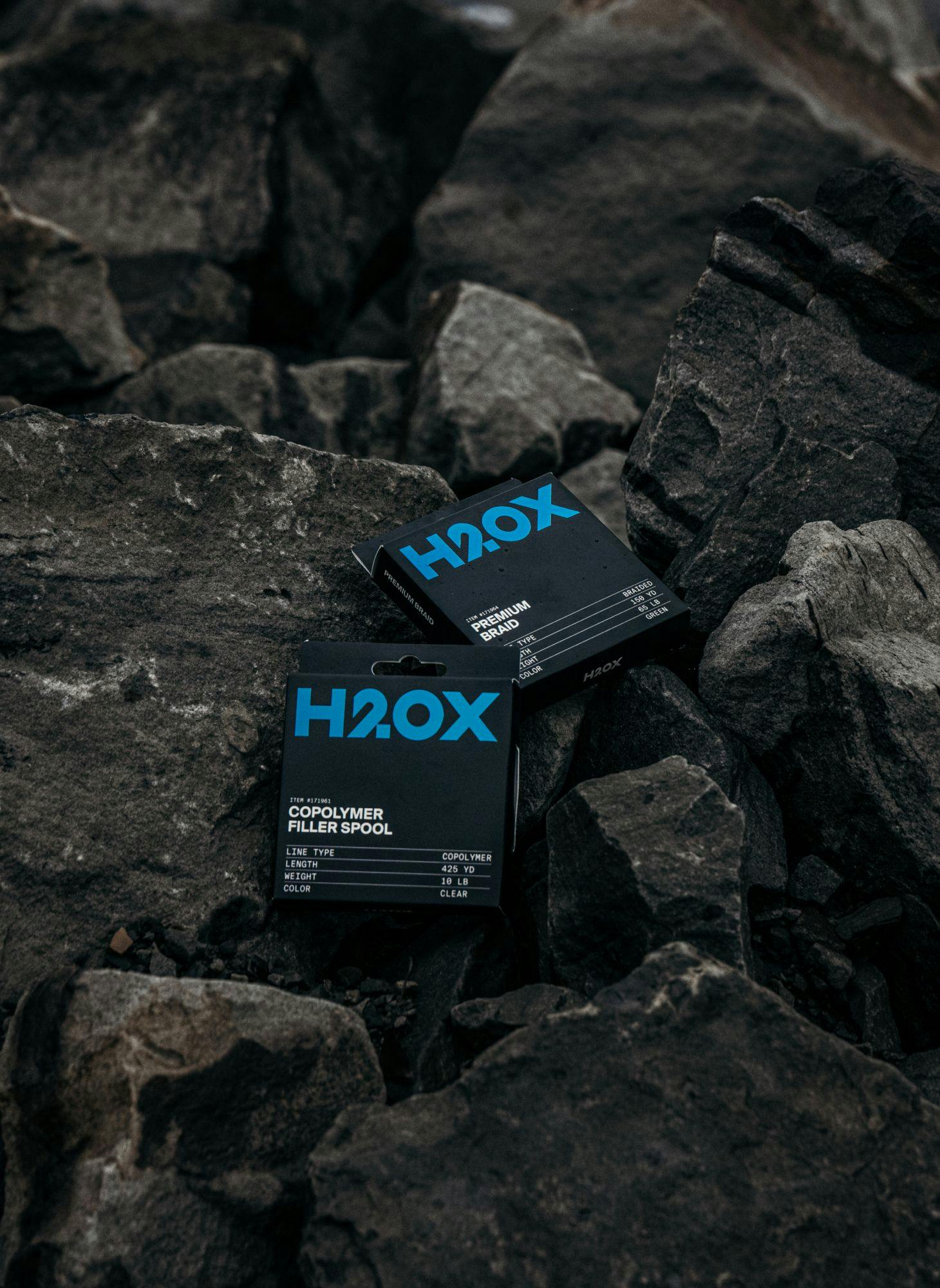Two H20X product boxes sitting on large rocks