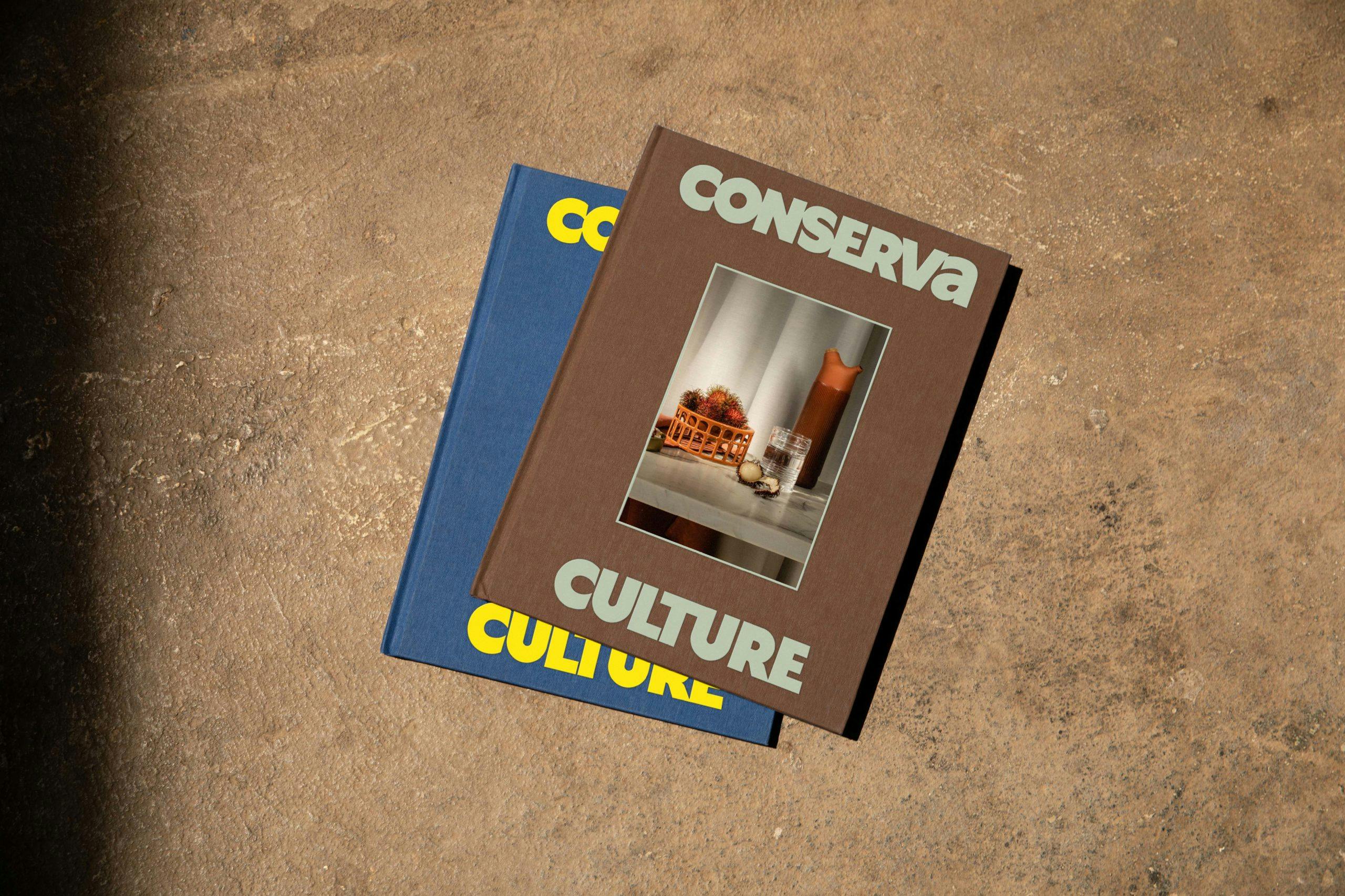 Two Conserva journals on a concrete floor