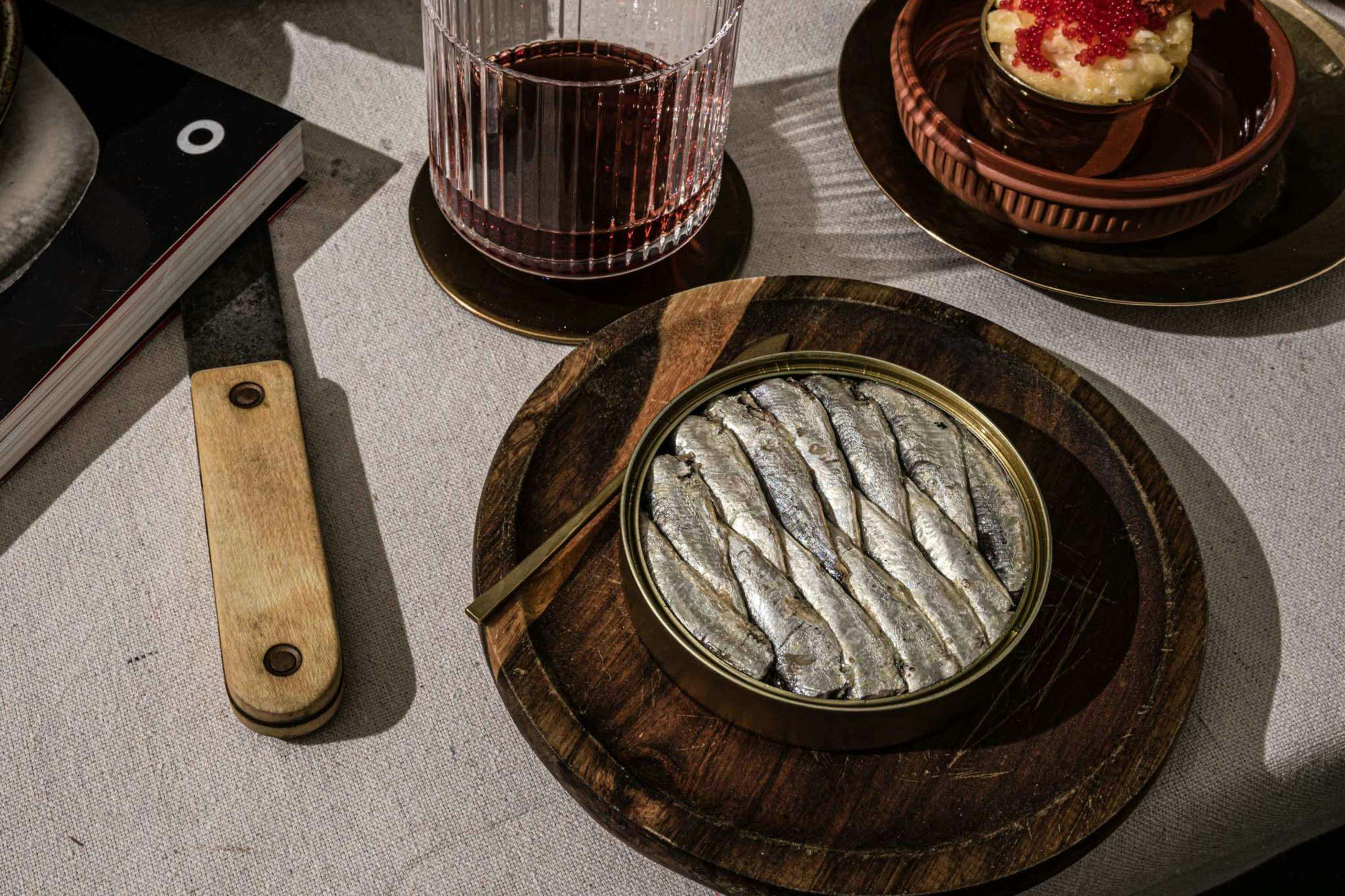 Can of sardines on a wood plate