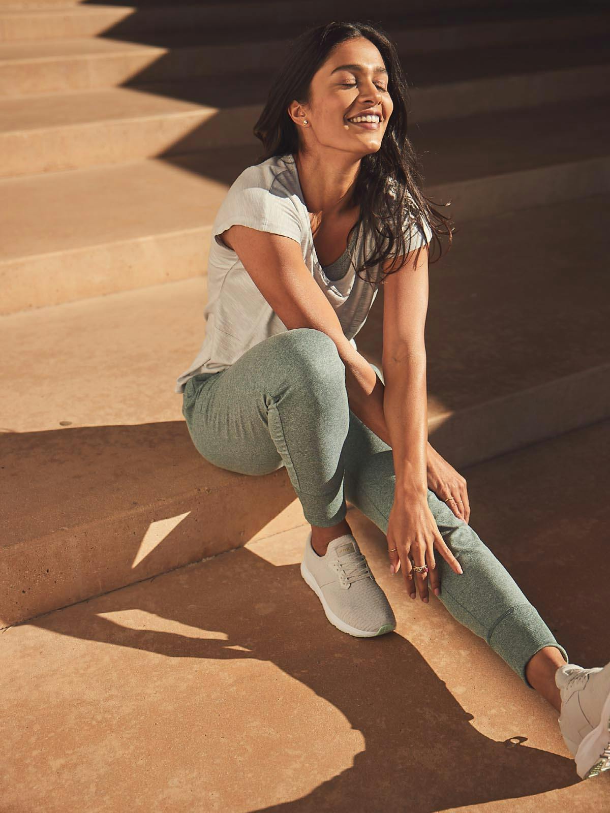 Woman Smiling on a Set of Stairs Outside