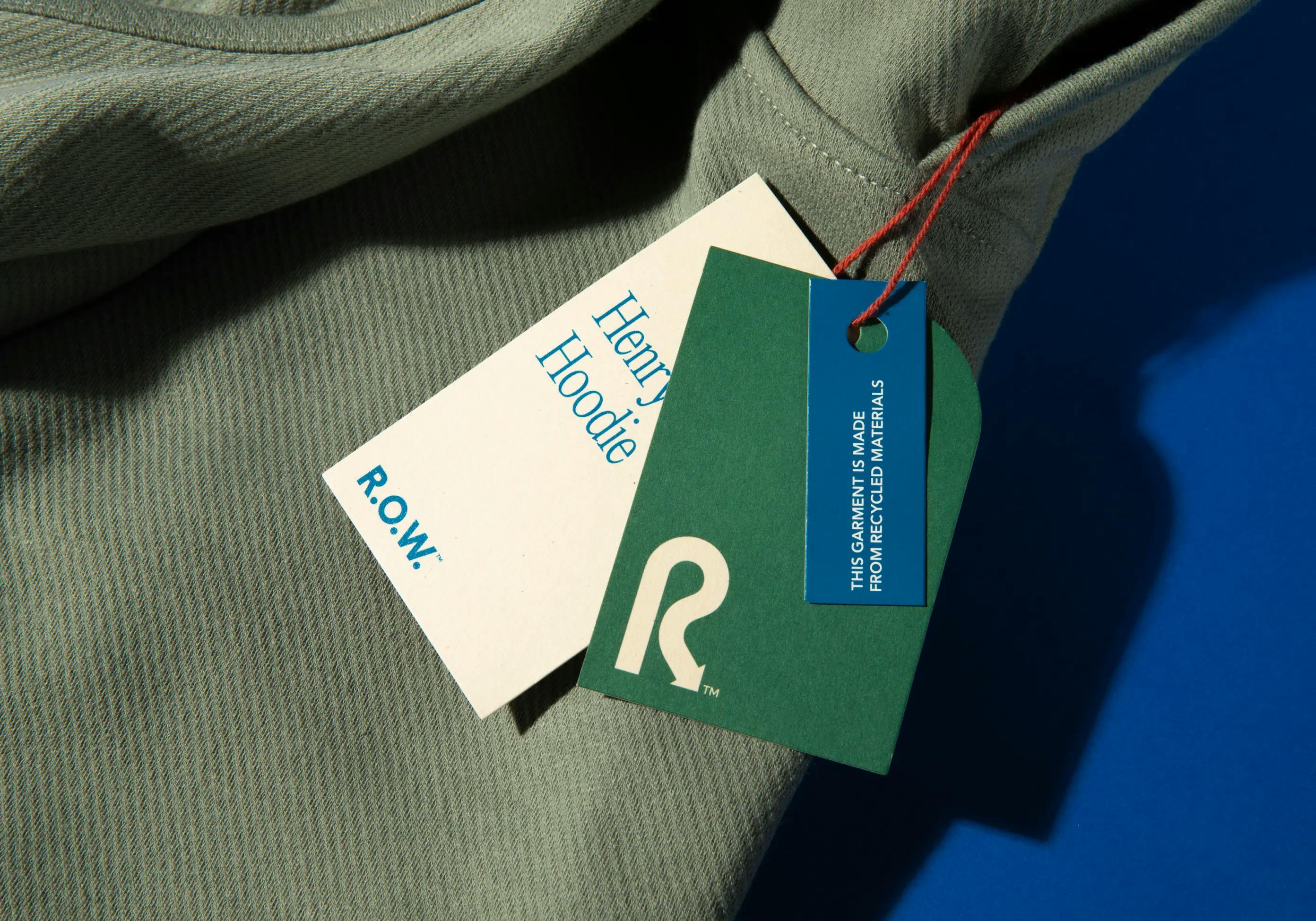 R.O.W Henry Hoodie and retail tags on a blue background