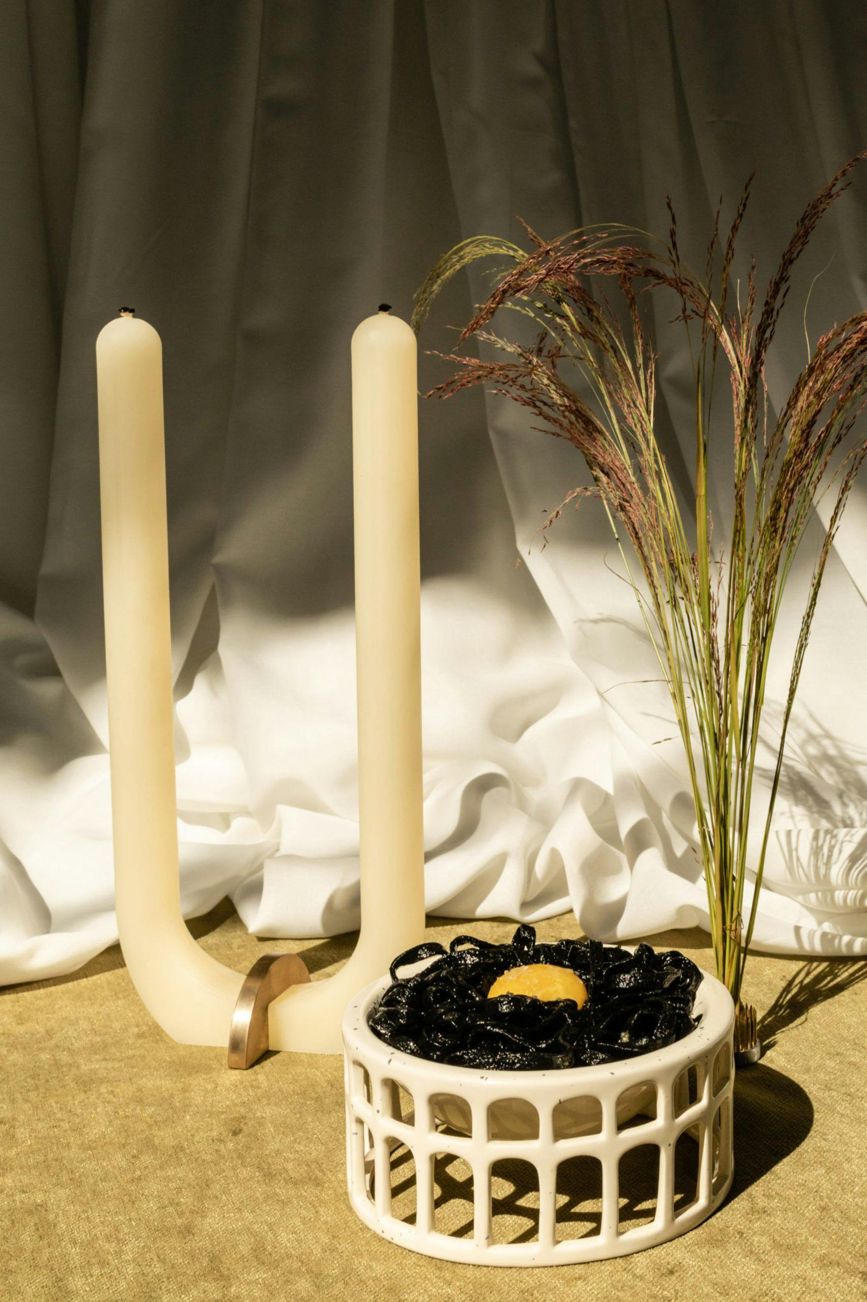 Candle and plant in front of a white curtain